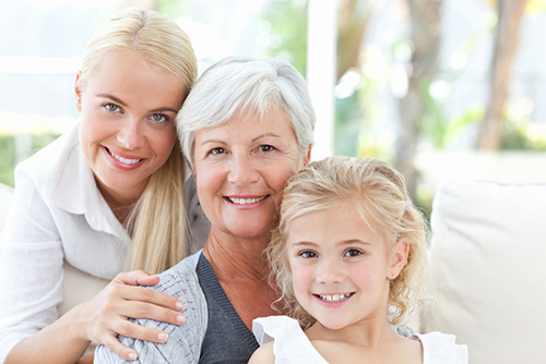 Grandmother sitting between her blonde daughter and blonde granddaughter